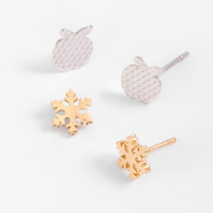 Aretes dúo de poste para niña con diseños de manzana y copo de nieve.