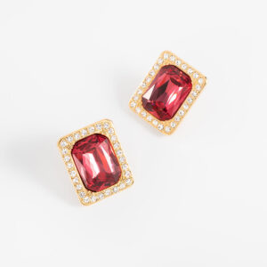 Aretes medianos con baño de oro y piedra roja rectangular.