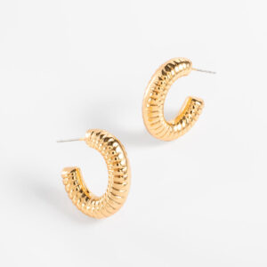 Aretes arracadas con baño de oro y diseño acanalado.